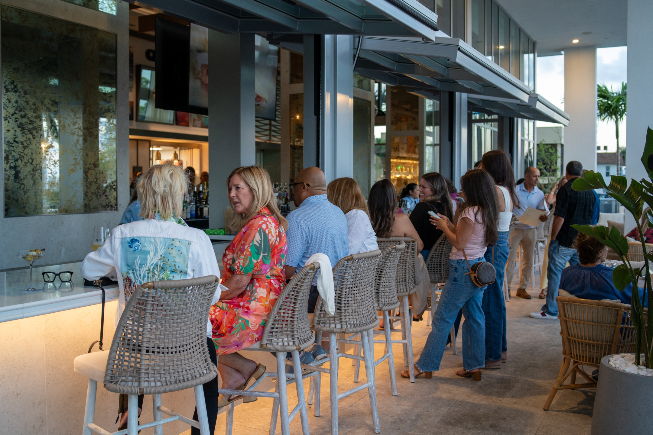 Guests seated at outdoor patio bar during happy hour